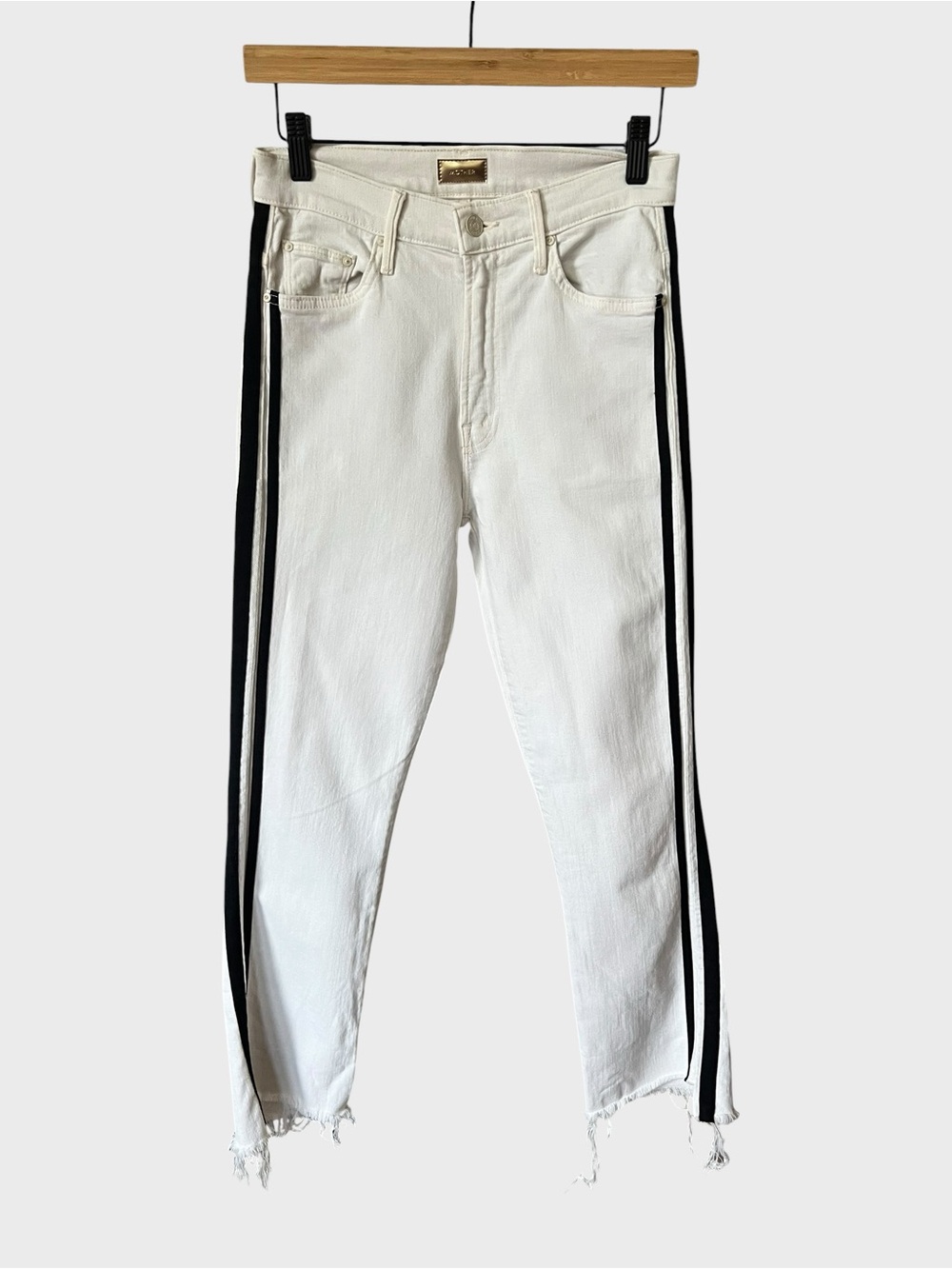 Mother denim white jeans with black sides stripes with raw hem.